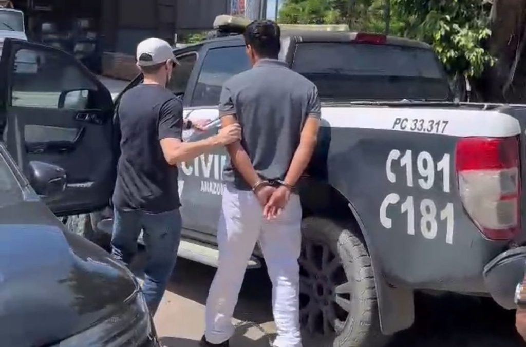 Homem algemado sendo conduzido por policiais civis após prisão por tentativa de feminicídio