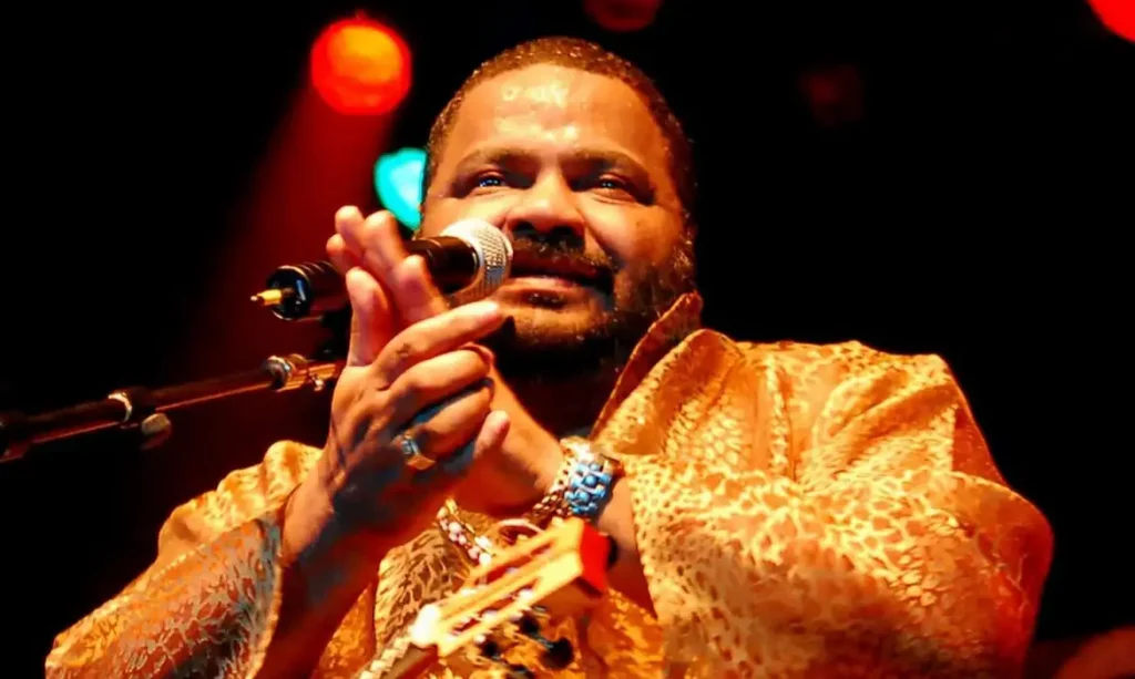 Arlindo Cruz sorrindo e segurando cavaquinho durante apresentação