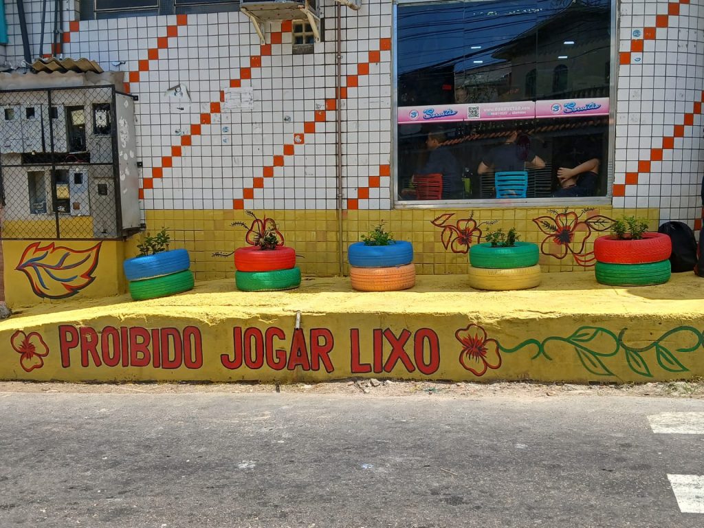Jardim urbano criado pela Semulsp em Manaus com pneus reciclados, flores e placas educativas