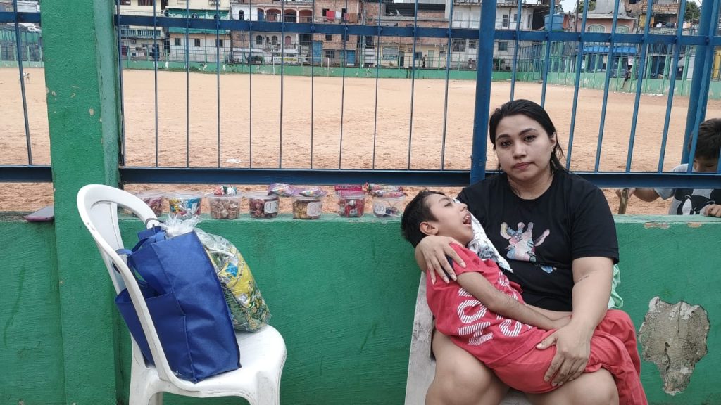Mãe de Manaus vende bombons para comprar carrinho adaptado para filho com paralisia cerebral e epilepsia.
