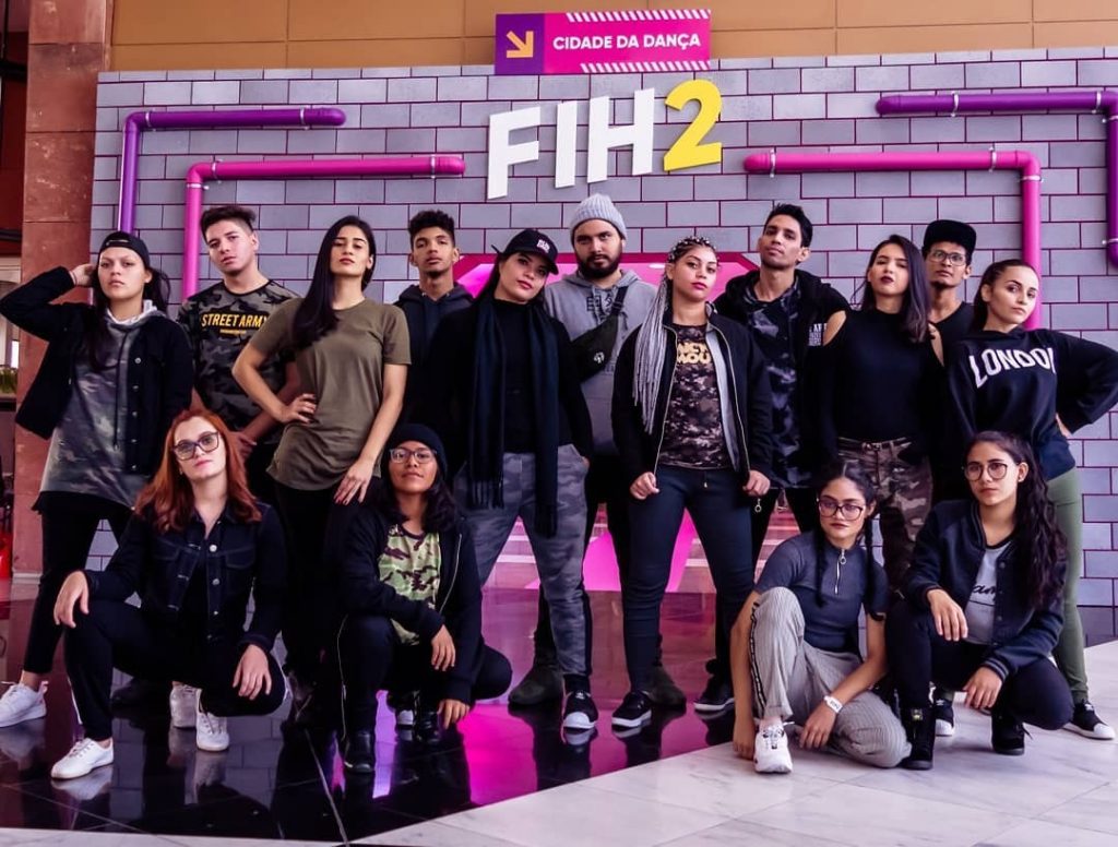 Dynamis 20 Anos: Foto de cena do espetáculo "A Fábrica" no Mir Ponta Negra, mostrando dançarinos e artistas da Companhia Dynamis.