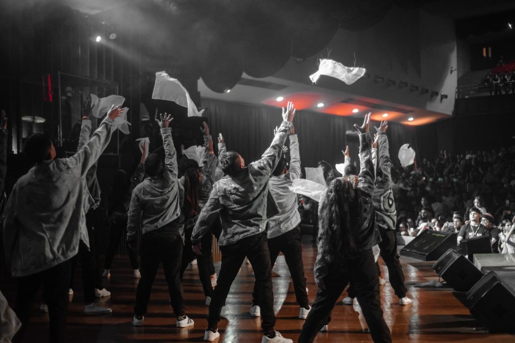 Dynamis 20 Anos: Foto de cena do espetáculo "A Fábrica" no Mir Ponta Negra, mostrando dançarinos e artistas da Companhia Dynamis.